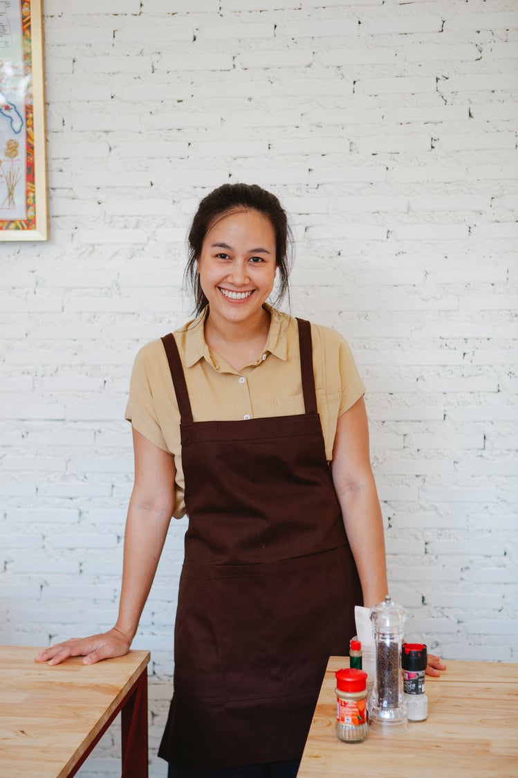 Woman Wearing Brown Apron Smiling